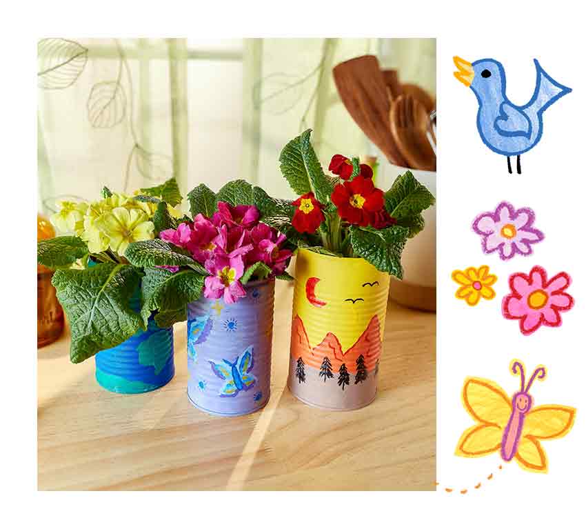 Painted tin cans with outdoor designs holding potted flowers